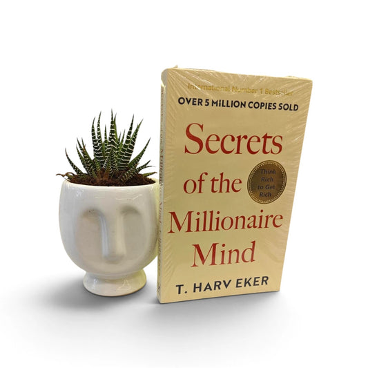 Zebra Haworthia succulent in white face planter with The Secrets of the Millionaire Mind book